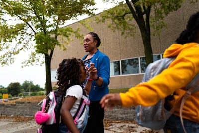 Students walk into school and high five