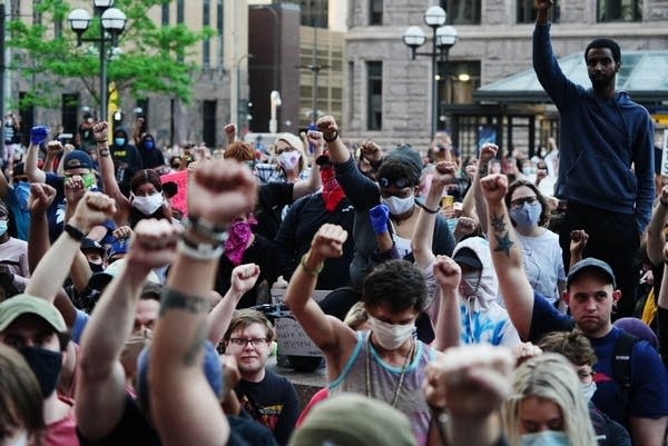 A crowd confronts a line of deputies outside the HennCo Government Center 