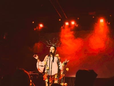 XINA sings into a microphone onstage at Fine Line.