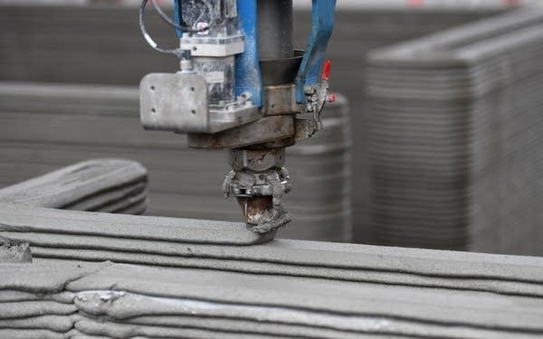 The head of a 3D printer applies the next layer of concrete to the walls of a house at the construction site in Beckum, western Germany, on November 26, 2020. - According to North Rhine-Westphalia's state government, Germany's first residential building constructed by 3D printing or additive manufacturing technique is currently being built in Beckum. (Photo by Ina FASSBENDER / AFP) (Photo by INA FASSBENDER/AFP via Getty Images)
