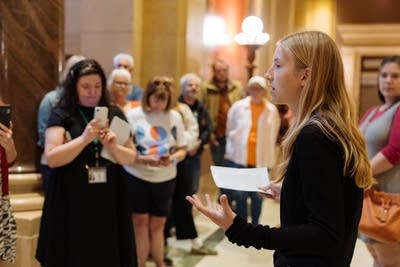 A teenage girl speaks to a group of rallyers in the Capitol.