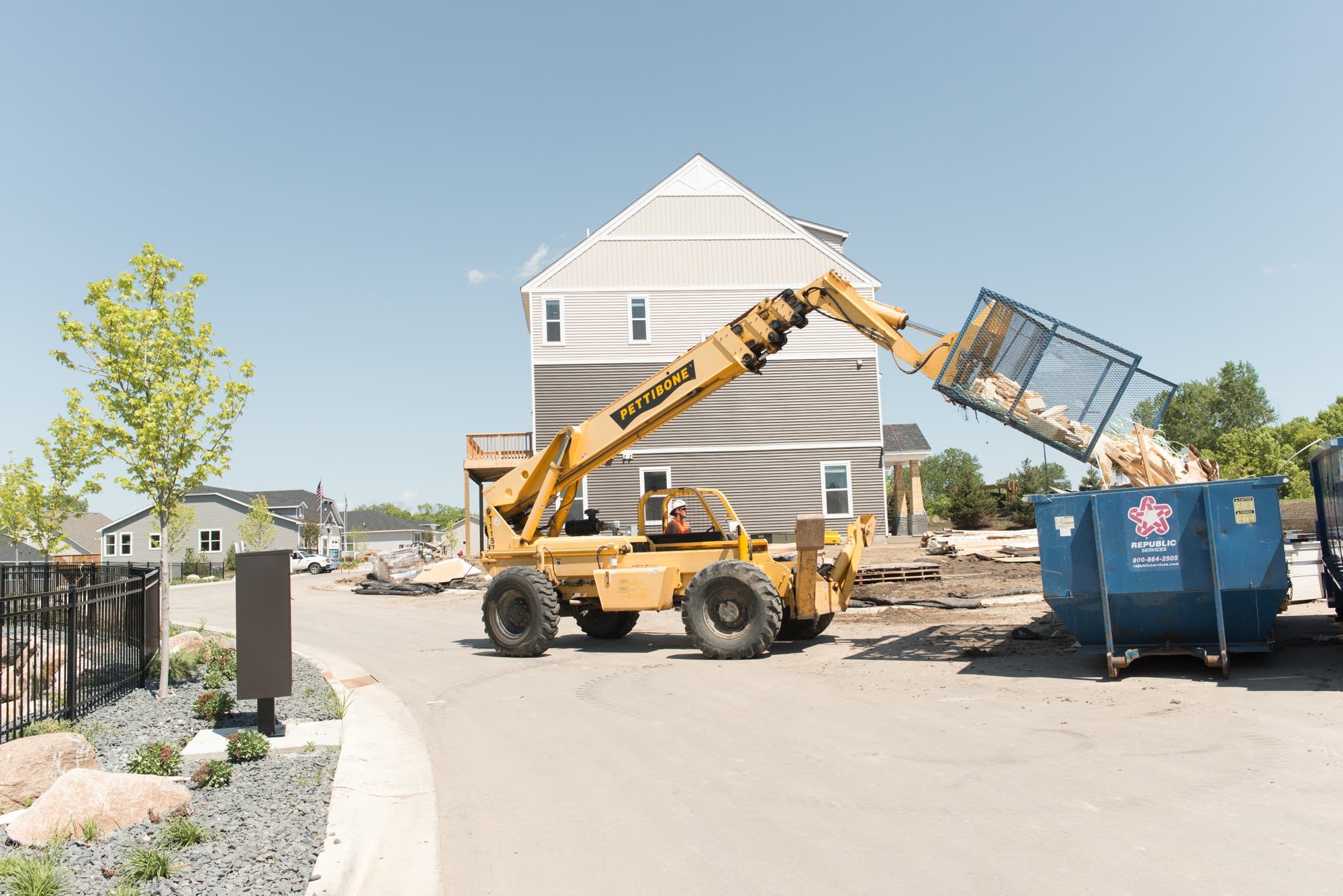 A backhoe dumps a load of scraps on May 25, 2018, at a construction site.
