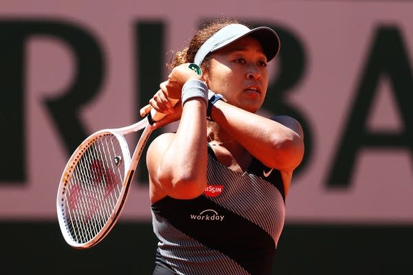 Naomi Osaka playing a backhand in her first round match against Patricia Maria Tig of Romania during Day One of the 2021 French Open.