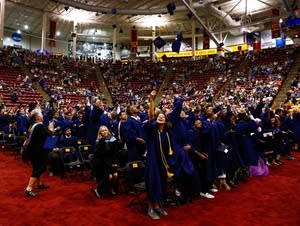 Kennedy graduates toss their caps into the air.