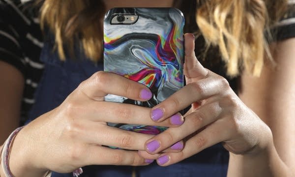 Rachel Whalen looks at her phone at her home.