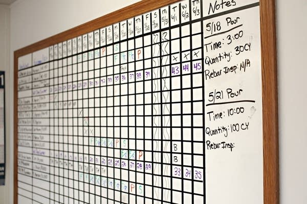 A white board shows a calendar in a grid layout.