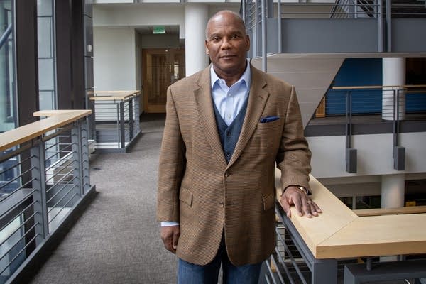 Man in brown suit posing for photo