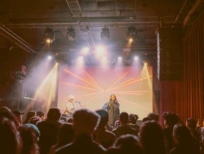 Dua Saleh sings into a microphone at Fine Line.