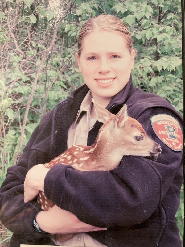 A women holds a fawn. 