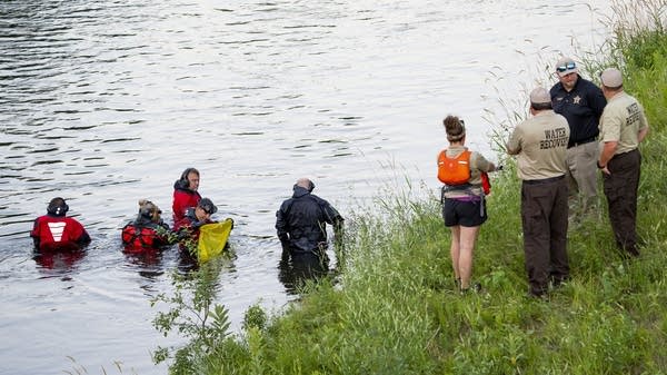 Authorities comb a river with metal detectors