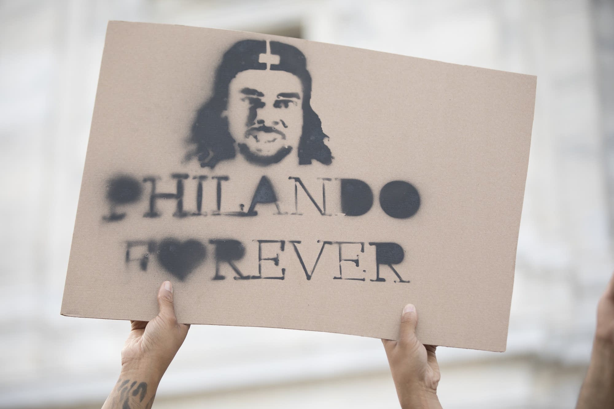 A sign in memory of Philando Castile is held on the steps of the capitol.