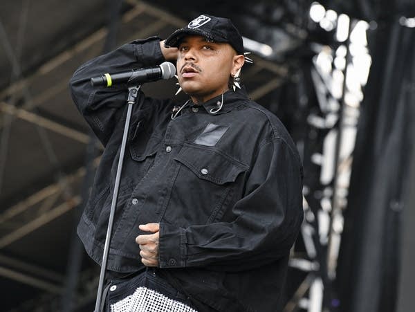 Jean Dawson wears a black denim jacket and sings into a microphone.