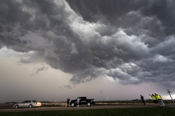 Storm chasers watch on a gravel road