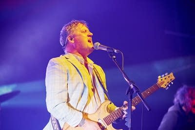 A musician sings and plays guitar onstage