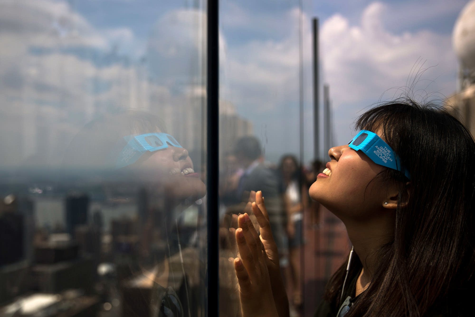 A woman views the solar eclipse at Rockefeller Center in New York City.