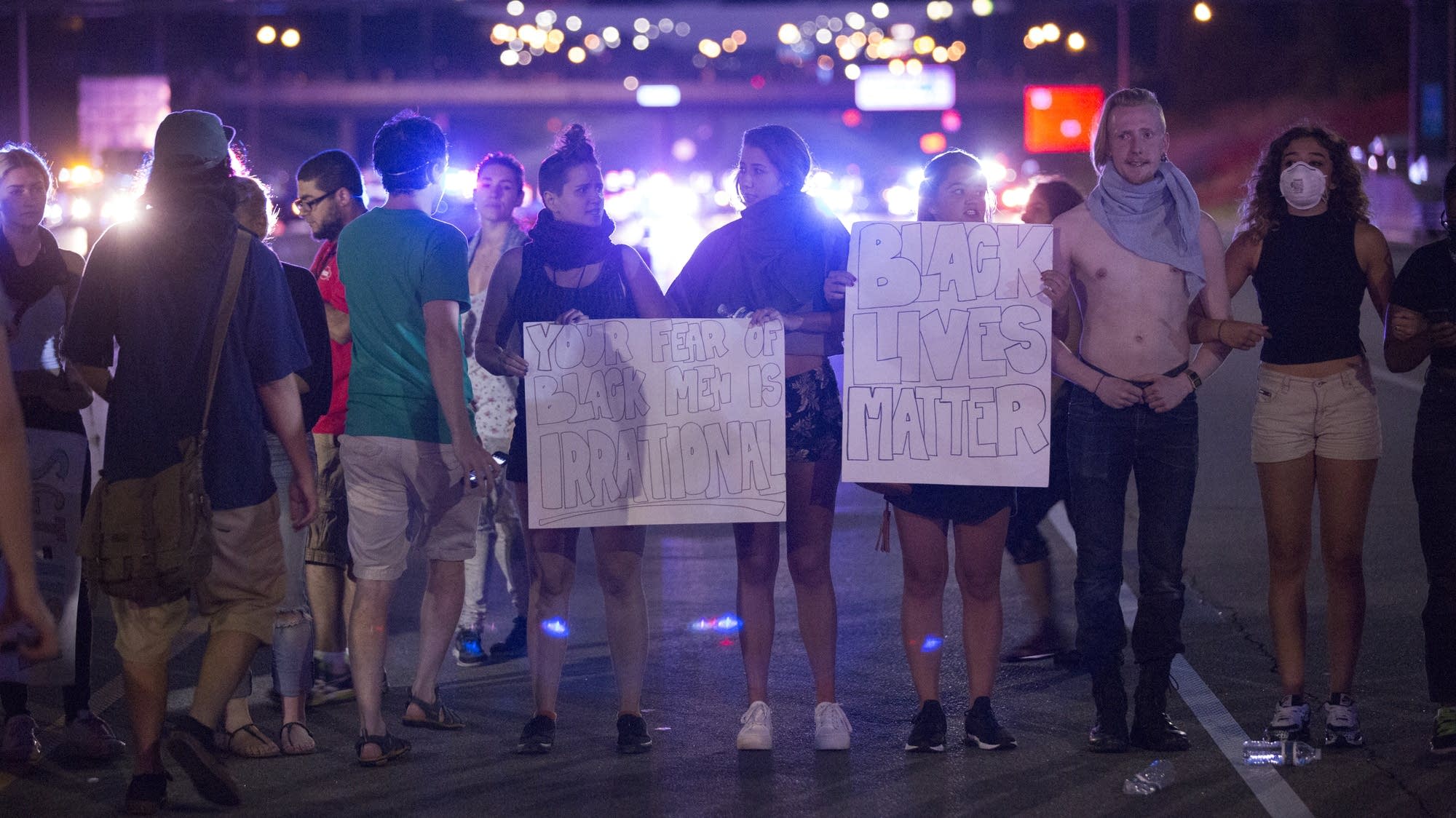 Protesters stand in a line to prepare for arrests.
