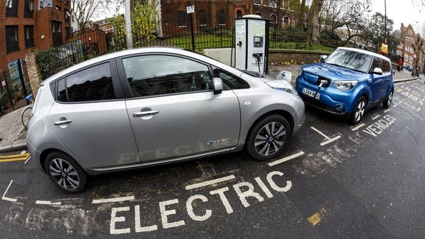 A Nissan Leaf, left, and Kia Soul charge on a London street. 