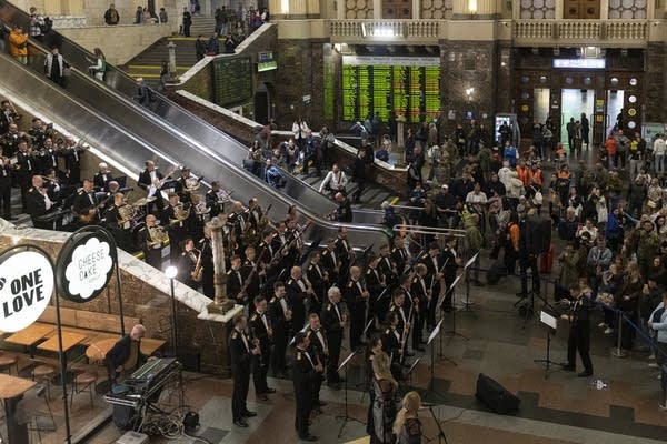 An orchestra performing in the main hall of a railway station