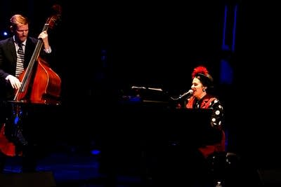 Two musicians performing together onstage in a theater