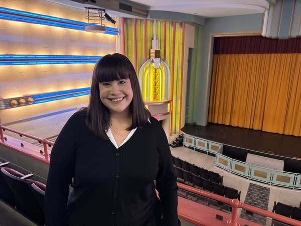 A woman poses for a photo in a theater