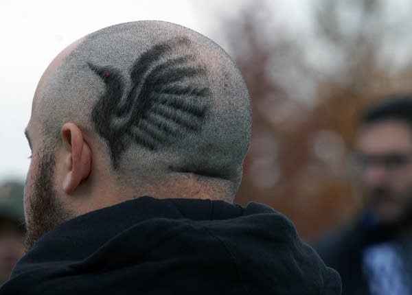 Hair grows in the shape of a loon on a bald man's head. 