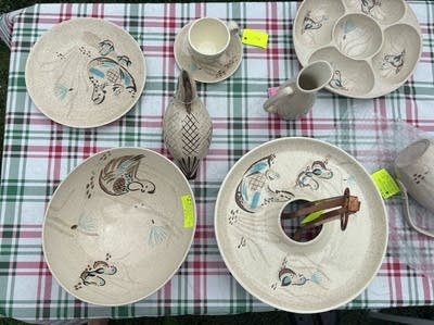 Aerial shot of several handmade bowls, plates and vases sitting on a table.