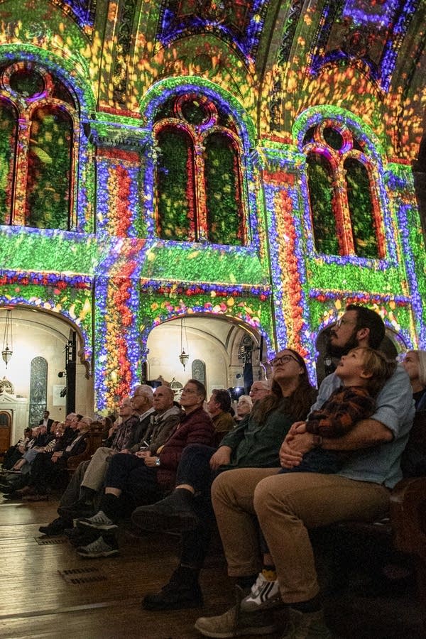 People look up to view the multicolored lights in the cathedral.