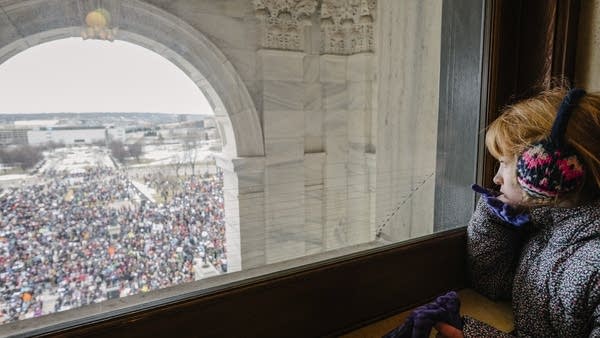 Seven-year-old Penny Peterson looks out the window of the State Capitol.