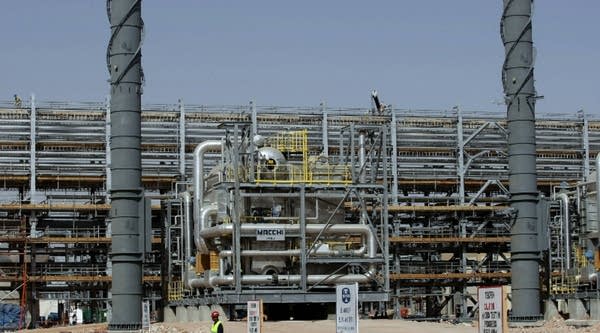 Laborers work at the construction site of Saudi Aramco's Al-Khurais central oil processing facility in the Saudi Arabian desert.