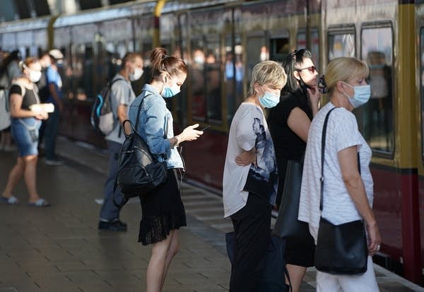 BERLIN, GERMANY - AUGUST 07: Commuters wearing protective face masks board a train during the novel coronavirus pandemic on August 07, 2020 in Berlin, Germany. Coronavirus infection rates are climbing again in Germany, from an average of 400 new cases per day about two weeks ago to over 1,100 yesterday, according to the Robert Koch Institute, Authorities sees Germans returning from vacation abroad as a likely strong contributor to the uptick in infections.