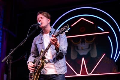 Man playing electric guitar and singing on stage