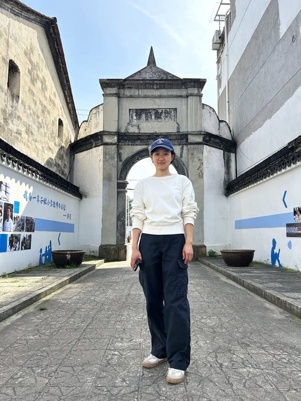 Liu Qing in front of Simin elementary. She uprooted her family to give her twins a less stressful education. (Charles Zhang/Marketplace)