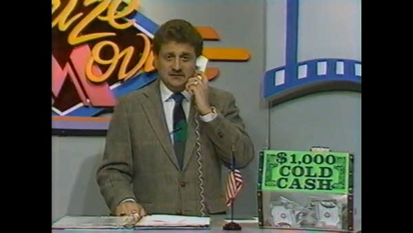 1980s local TV movie night host talking to viewer on a phone on set