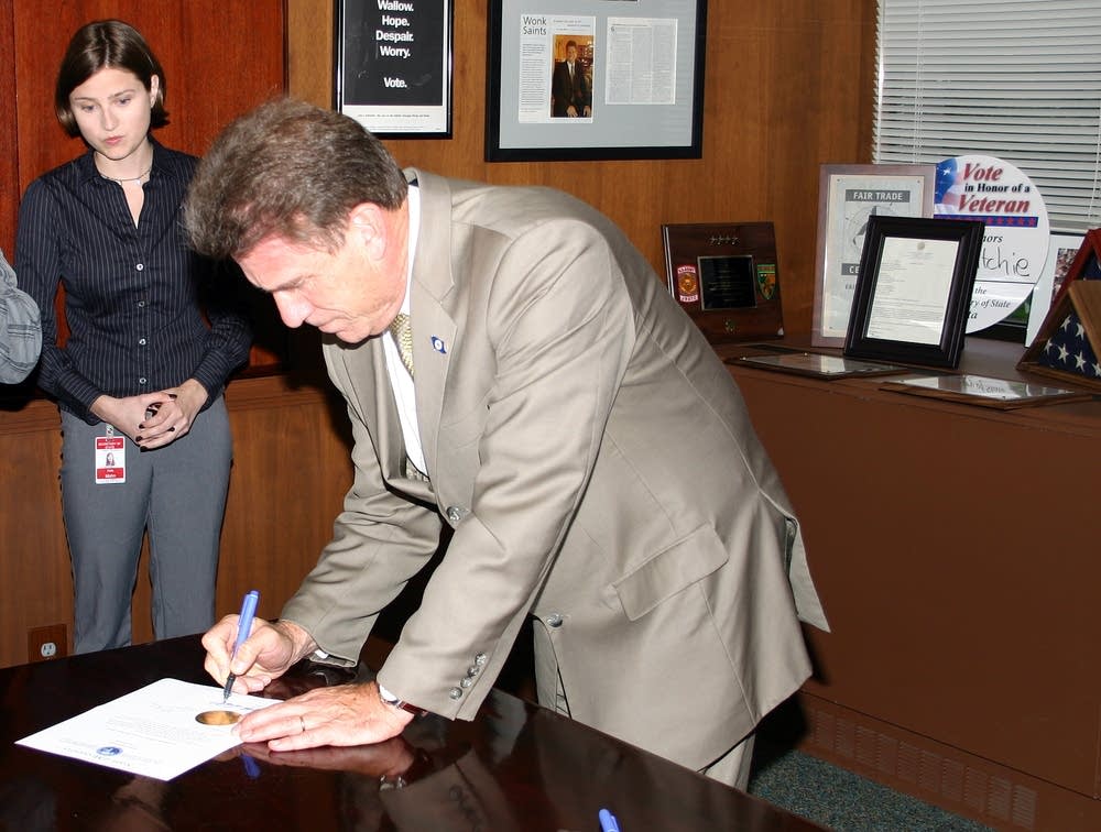 Mark Ritchie signs the election certificate