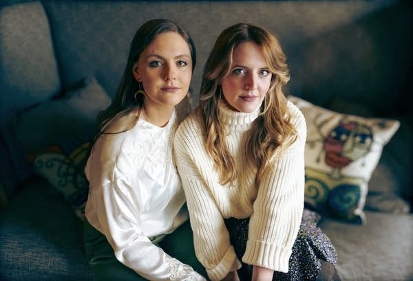 Two women sit together for a portrait